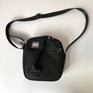 Detail of black canvas crossbody bag featuring adjustable strap and fashion label pocket