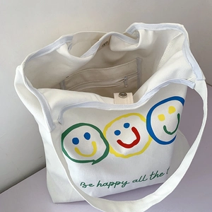 Detail view of white canvas tote bag showing inner pocket, magnetic buckle and smiley print