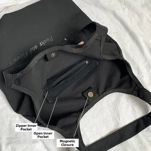 Detailed interior of black canvas tote featuring zipper pocket and magnetic snap closure