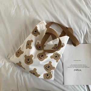 Détail d'un sac cabas en toile blanche avec imprimés koalas marron et anses résistantes