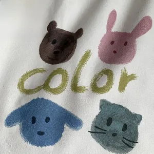 Close-up of digital animal prints and green 'color' text on white canvas bag