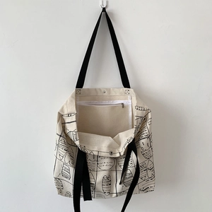Detail of canvas tote bag showing interior zipper pocket and secure metal snap closure