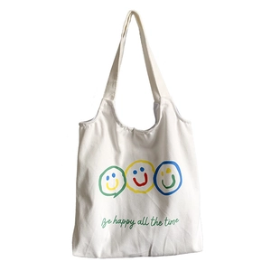 White canvas tote bag with colorful smiley faces and Be happy all the time slogan
