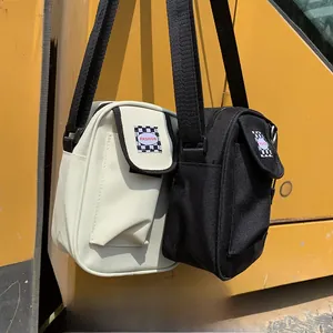 Detail showing mini canvas crossbody bags in black and white with checkerboard patch