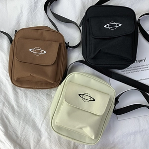 Detailed view of canvas crossbody bags in brown, black, and green with planet prints