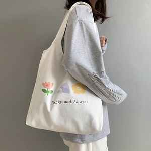 Detailed shot of white canvas tote bag featuring colorful Peaks and Flowers illustration