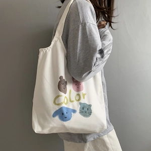 Detail of white canvas tote bag featuring cute hand-drawn animal prints and color text