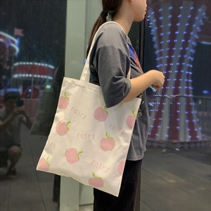 White canvas tote bag with pink peach pattern and fairy text for casual daily use