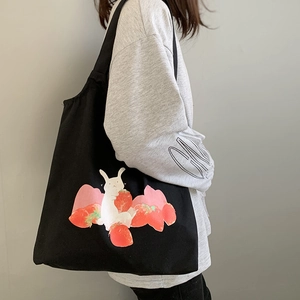 Détail du sac cabas en toile noire avec illustration de lapin et de fraises mignonnes
