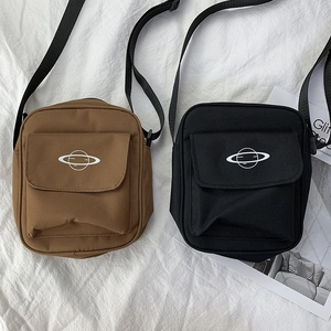 Detail view of brown and black canvas crossbody bags with Saturn print and zipper