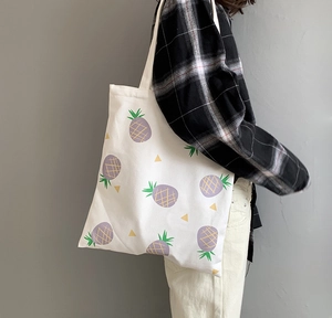 Détail du sac fourre-tout en toile blanche avec motifs ananas violets et anses solides
