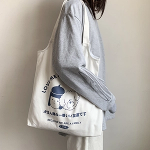 Détail du sac cabas en toile blanc cassé avec imprimé graphique bleu marine fille et chien