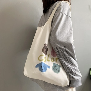 Detail of off-white canvas tote bag featuring colorful cartoon animals and Color text