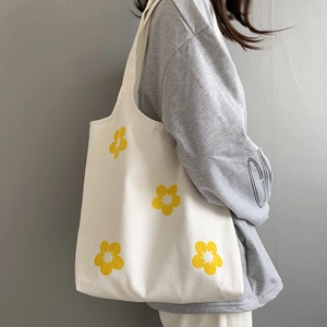 Detail of floral canvas tote bag featuring yellow flower prints and large capacity design