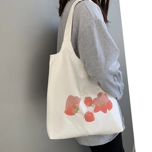 Détail d'un sac cabas en toile blanche avec motif de lapin et fraises dessiné à la main