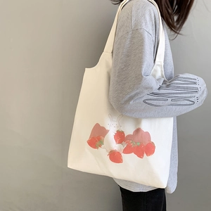Détail du sac cabas en toile blanche avec motif lapin et fraise de style dessin animé