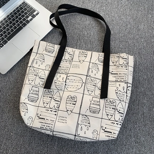White canvas tote bag with black cartoon graffiti prints and long shoulder straps