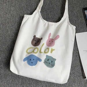 Detail of white canvas tote bag featuring cute cartoon animals and color typography print