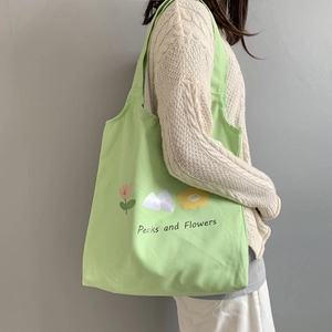 Detail shot of light green floral canvas tote bag showing its large capacity and print