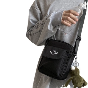 Minimalist black canvas crossbody bag with planet embroidery and green plush frog charm