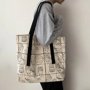 Off-white canvas tote bag with hand-drawn black doodles and durable black shoulder straps