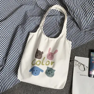 Detail of white canvas tote bag with hand-drawn animal prints and soft fabric texture