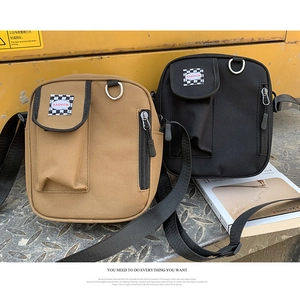 Close-up of canvas crossbody bags in khaki and black with fashion checkered labels
