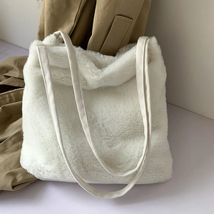 Gros plan d'un sac cabas en fausse fourrure blanche montrant sa texture pelucheuse douce
