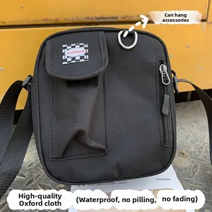 Detail of waterproof canvas crossbody bag showing velcro pocket and metal D-ring attachment