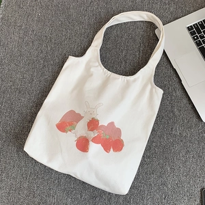 Détail du sac en toile avec des motifs mignons de lapin et de fraises dessinés à la main