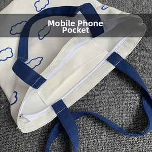 Détail du cabas en toile avec une poche intérieure pour téléphone et fermeture éclair