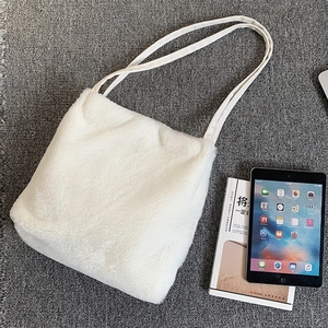 Vue à plat d'un sac cabas en fausse fourrure blanche avec anses en toile robuste