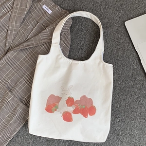 Détail du sac fourre-tout en toile blanche avec motif lapin et fraise imprimé