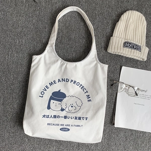 Détail du sac en toile blanc avec illustration originale fille et chien et texte
