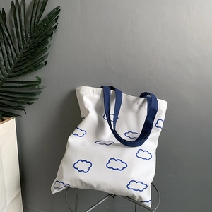 Détail du sac cabas en toile avec motif nuage bleu et anses bleu marine robustes