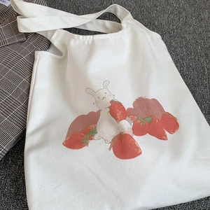 Détail de l'imprimé mignon lapin et fraise sur le sac fourre-tout en toile blanche