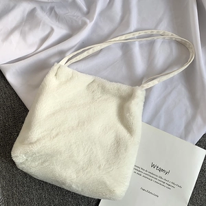 Détail de la texture douce en peluche blanche d'un sac cabas carré pour l'hiver