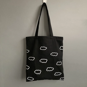 Détail du sac cabas en toile noire avec motif nuage blanc suspendu au crochet