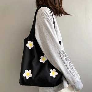 Detail showing the large capacity and durable black canvas material with daisy floral print