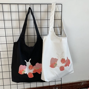 Détail des sacs fourre-tout en toile noir et blanc avec imprimés lapin mignon et fraises