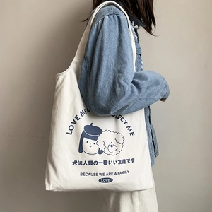 Détail du sac fourre-tout en toile blanche avec imprimé graphique de fille et chien