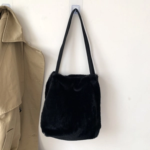 Détail d'un sac cabas en fausse fourrure noire avec texture pelucheuse et bandoulières