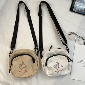 Détail de deux sacs à bandoulière en toile avec imprimés moutons et poches avant