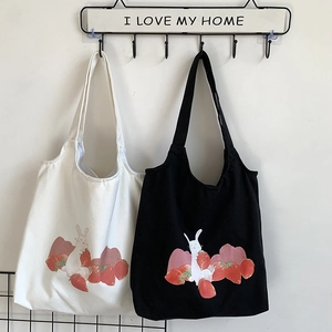 Détail d'un sac cabas en toile de coton avec imprimé mignon de lapin et de fraise