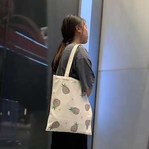 Détail du sac cabas en toile blanche avec imprimé ananas violet et design spacieux