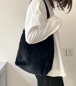 Vue latérale d'un grand sac fourre-tout noir en fausse fourrure porté par un mannequin