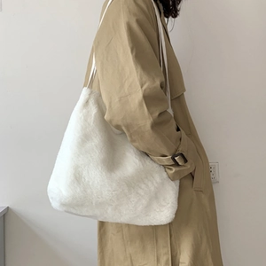 Vue latérale d'un sac cabas blanc en fausse fourrure porté avec un trench-coat beige