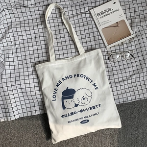 Détail du sac cabas en toile blanche avec illustration d'une fille de dessin animé