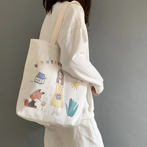 Detail of white canvas tote bag featuring artistic girl and fox illustration prints