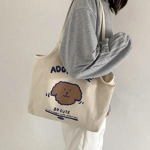 Beige Canvas-Tragetasche mit süßem Hunde-Cartoon-Print getragen von einem Modell an der Schulter